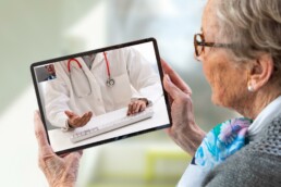 Seniorin spricht via Tablet mit ihrem Arzt