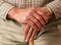 Blick auf die Hände eines älteren Herr mit Stock