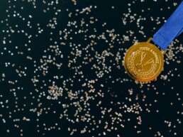 Eine Goldmedaille auf schwarzem Untergrund mit goldenem Glitzer
