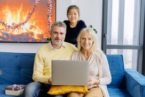 Mann, Frau und Mädchen mit Laptop auf dem Sofa.