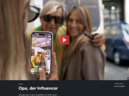Eine Frau fotografiert zwei ältere Frauen auf der Straße mit einem Smartphone.